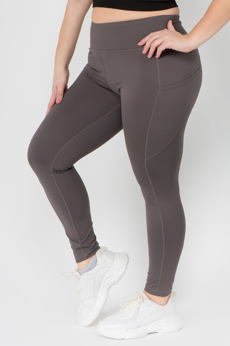 Women's charcoal grey active high rise capri leggings workout leggings. -  Flattening elasticized waistband with interior pocket and back zipper pocket  - Figure sculpting skinny leg design - Exterior side pocket along